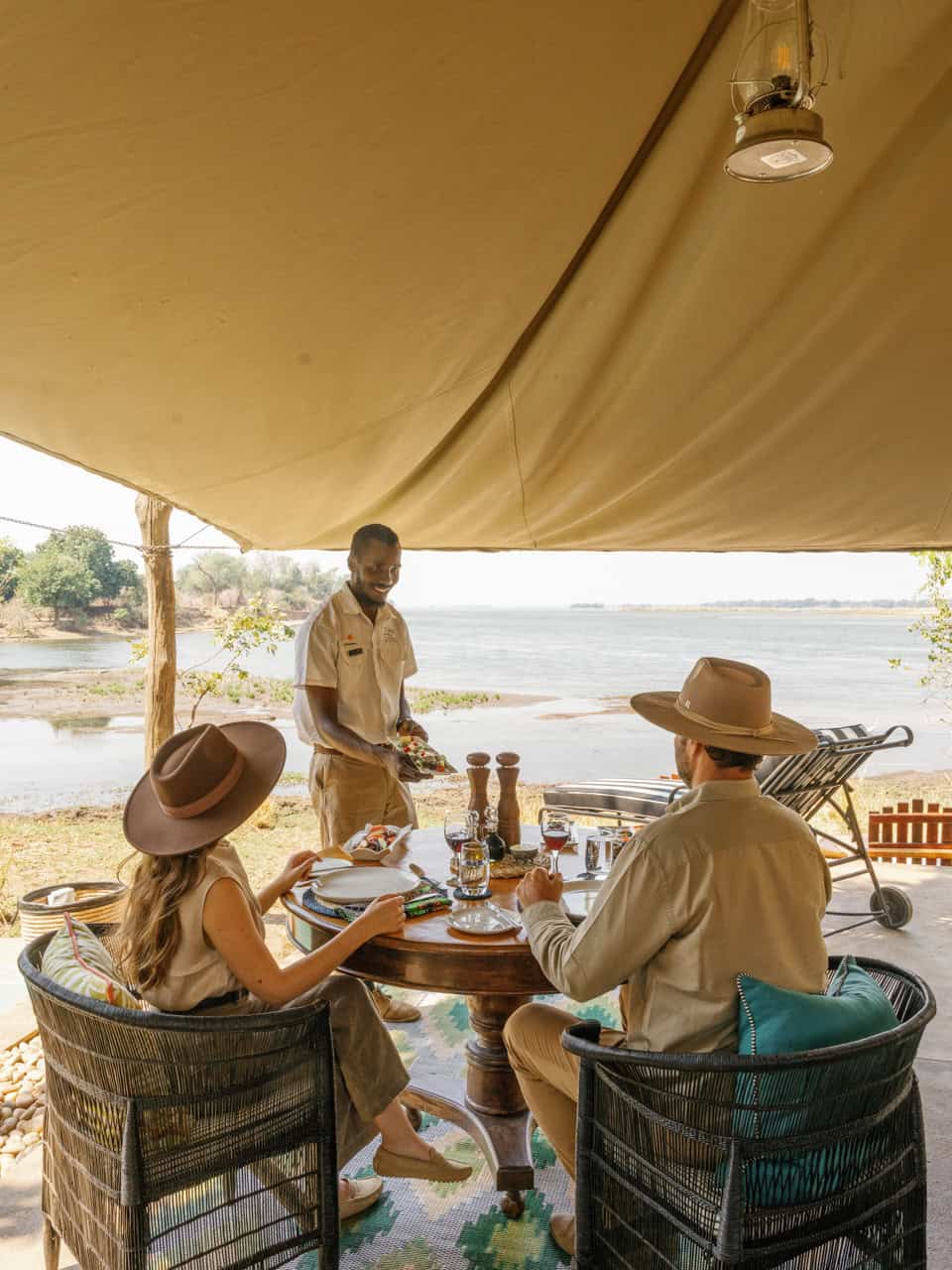 Two guests being served a private lunch in the honeymoon suite at Time + Tide Chongwe Camp in Zambia