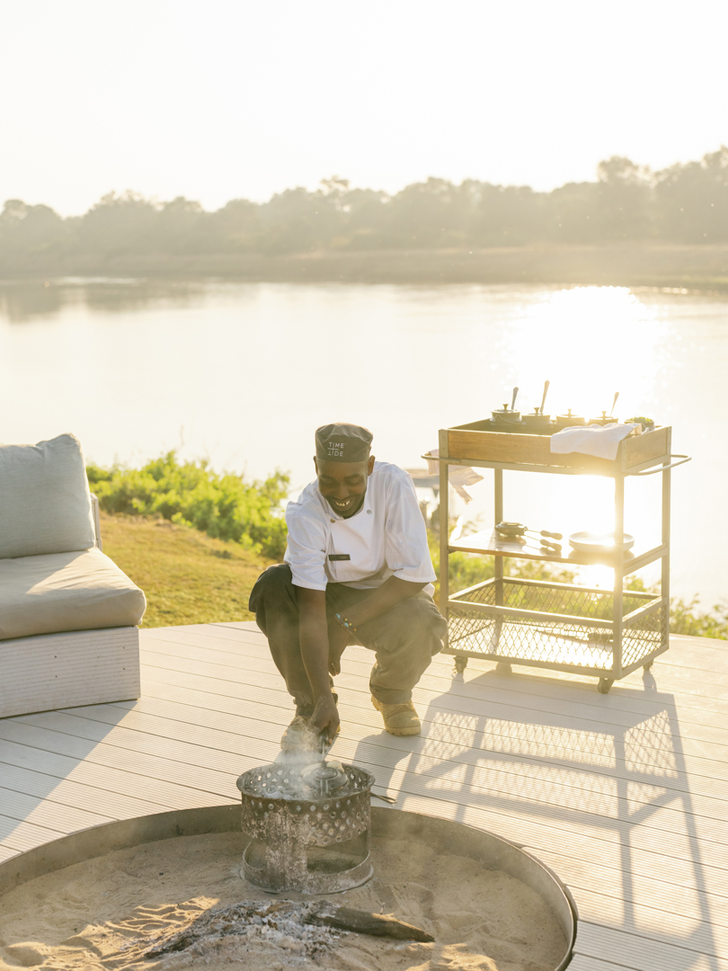A chef preparing the outdoor open fire at Time + Tide Chinzombo in the South Luangwa National Park Zambia